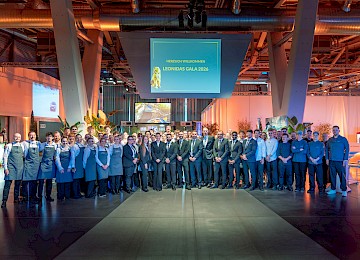Teamfoto Leonidas Sportgala (c) Gassner Gastronomie, Foto Hechtfisch: Das Bild zeigt Mitarbeitende aus Service, Küche und Organisation der Leonidasgala 2026, welche gemeinsam für ein Gruppenfoto in der Eventlocation posieren.